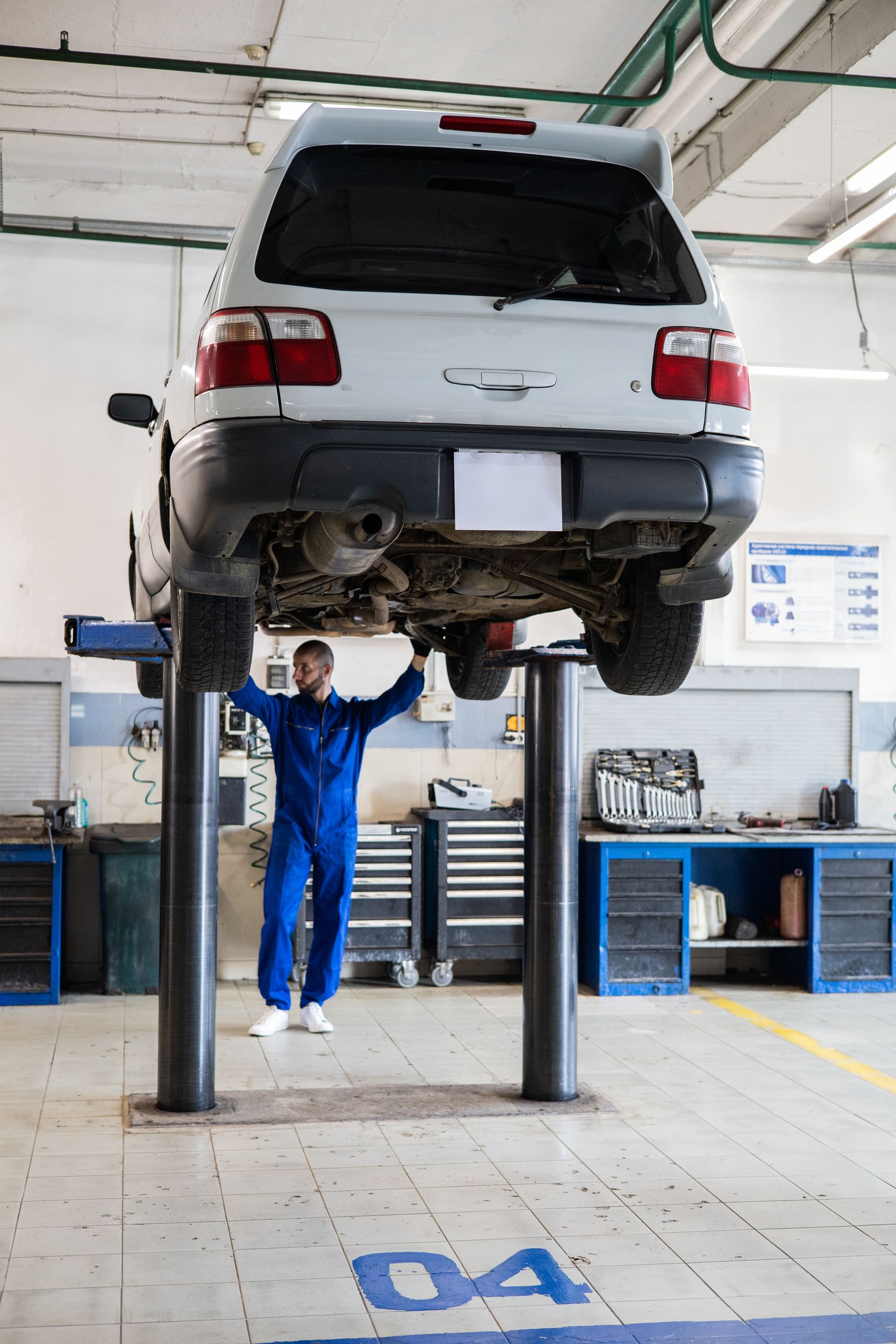 Technician inspecting a car raised on a lift